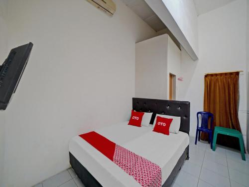 棉兰OYO 90355 Darussalam Inn的一间卧室配有一张床和一张蓝色椅子