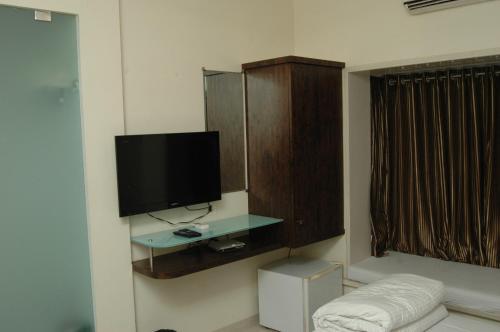 孟买Hotel Causeway, Colaba的客厅设有壁挂式平面电视。
