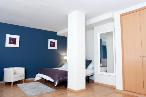 略夫雷加特河畔奥斯皮塔莱特费拉复式公寓的一间卧室设有一张床和蓝色的墙壁
