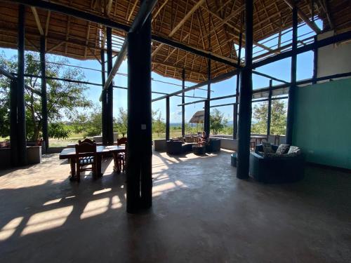 KatunguruEnshama Game Lodge and Campsite的一个带桌椅和窗户的大型凉亭