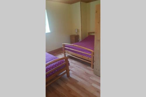 利特里姆Cottage ideal for Family's & private lake access的紫色床单的客房内的两张床