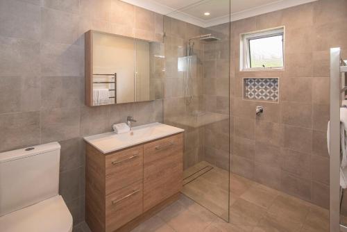 邓斯伯勒邓斯伯勒海滩小屋度假酒店的浴室配有卫生间、盥洗盆和淋浴。