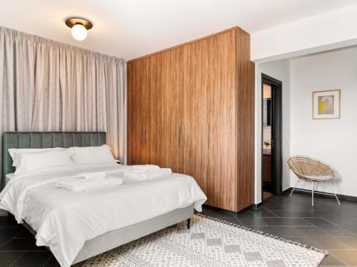 拉纳卡LIV URBAN Suites的一间卧室配有一张大床和一个木制橱柜