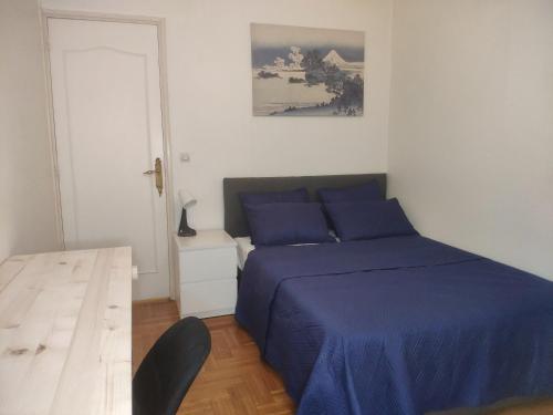 诺瓦西勒塞克Le noisy的一间卧室设有蓝色的床和白色的墙壁