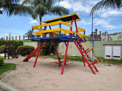 圣佩德罗-达阿尔德亚Residencial Marina Club的沙地里一个有丰富多彩的游戏结构的游乐场