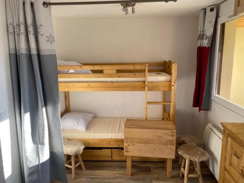 萨莫安斯Samoëns 1600 les cimes的客房内的双层床,配有2张凳子