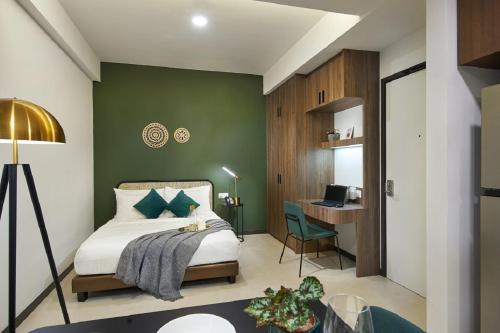 新加坡The Initial Residence的一间卧室配有一张带绿色墙壁的床