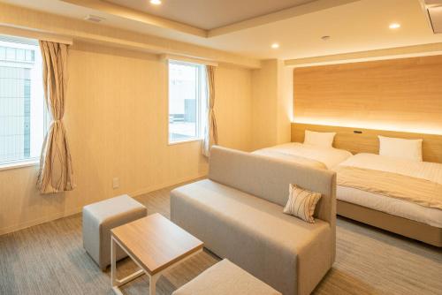 旭川HOTEL AMANEK Asahikawa的酒店客房,配有床和沙发