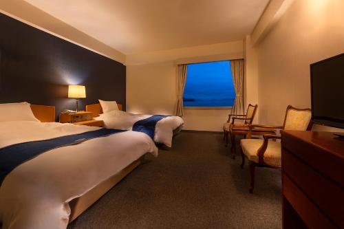 仓敷仓敷海滨酒店的酒店客房设有两张床和窗户。