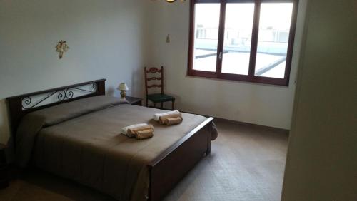 吉诺萨滨海Appartamento Palazzo Galante的一间卧室配有一张床,上面有两条毛巾