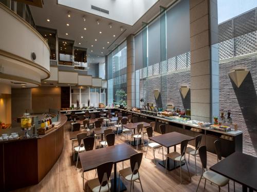 宫崎ART HOTEL Miyazaki Sky Tower的大楼内带桌椅的餐厅