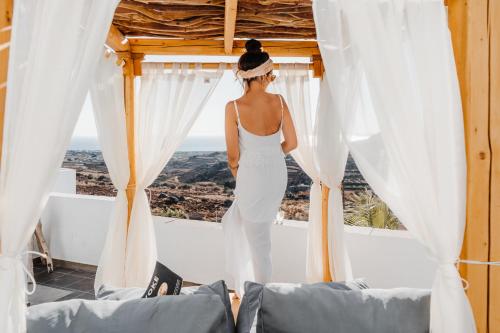 纳克索斯岛卡斯特拉基Naxos Aethereal View的穿着白色衣服的女人,从窗户望出去