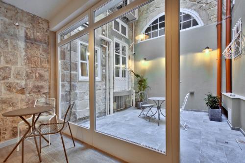 瓦莱塔Chateau La Vallette - Barrakka Suite的客房设有窗户和桌椅。