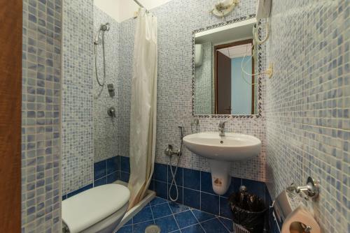 罗马Hotel Beauty Palace - Vertex Group的蓝色瓷砖浴室设有水槽和淋浴