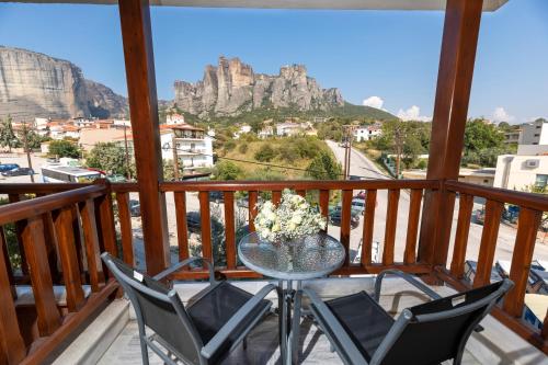 卡兰巴卡Famissi Hotel的悬崖景阳台的桌椅