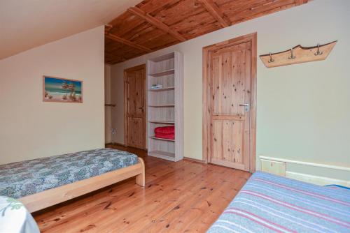 尤卡尔内奥佐利尼度假屋的一间卧室配有一张床,铺有木地板