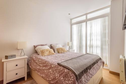 拉科鲁尼亚Precioso apartamento nuevo en el centro de A Coruña!的白色的卧室设有床和窗户