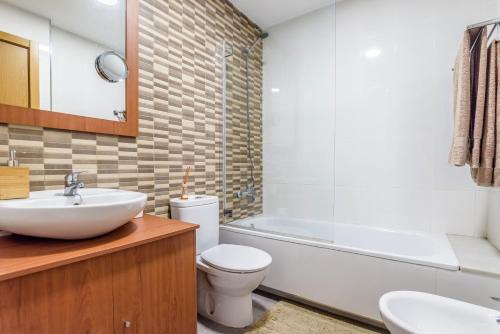 拉科鲁尼亚Precioso apartamento nuevo en el centro de A Coruña!的浴室配有盥洗盆、卫生间和浴缸。