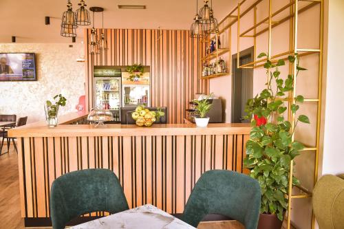 RinasAirport Garden Hotel的餐厅设有1间带绿色椅子的酒吧
