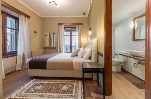 阿拉霍瓦Ef Zin Hotel Arachova的一间卧室配有一张床,浴室设有水槽