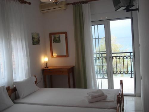 斯卡拉马里昂Veroniki Apartment的一间卧室设有两张床和大窗户