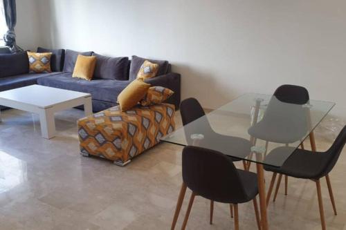 诺阿瑟Apartment Near & close to Casablanca Mohammed V International Airport的客厅配有玻璃桌和沙发