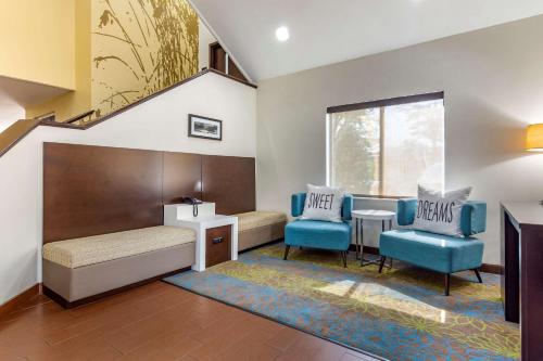 亨德森Sleep Inn Henderson I-85的配有一张床和两张蓝色椅子的房间