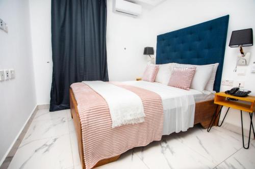 Sere KundaMica Apartments的一间卧室配有一张大床和蓝色床头板