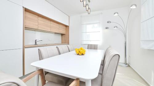 布罗托尼贾Villa Leon的白色的用餐室配有白色的桌椅