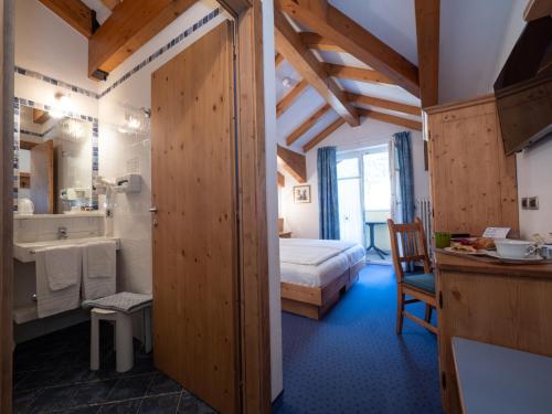 迪马罗斯托博斯克酒店的一间卧室配有一张床,浴室设有水槽