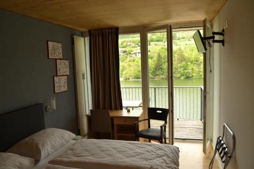 莱斯布里内特Hotel Les Rives Du Doubs的配有一张床、一张书桌和一扇窗户的酒店客房