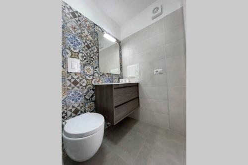 孔韦尔萨诺Casa Vacanze Magrè的一间带卫生间、水槽和镜子的浴室