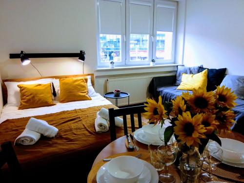 瓦多维采Orange Apartament的一间房间,里面设有一张床和一张鲜花桌