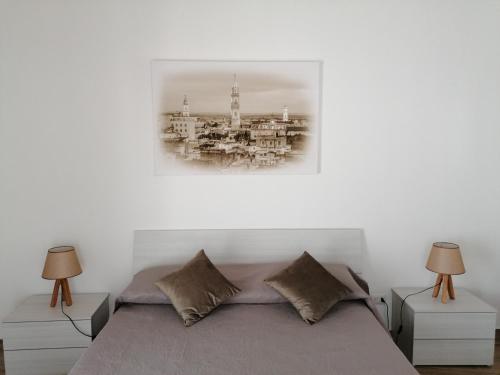 安德里亚B&B Curtopassi的一间卧室配有一张带两盏灯和一张照片的床。