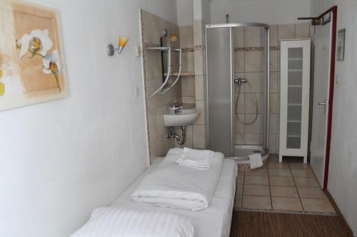 汉堡里列恩霍夫酒店的浴室配有水槽和带白色毛巾的淋浴