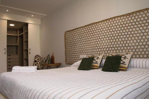 奥伦塞Apartamento Dúplex Estación Manzaneda的卧室配有一张白色的床和大型床头板