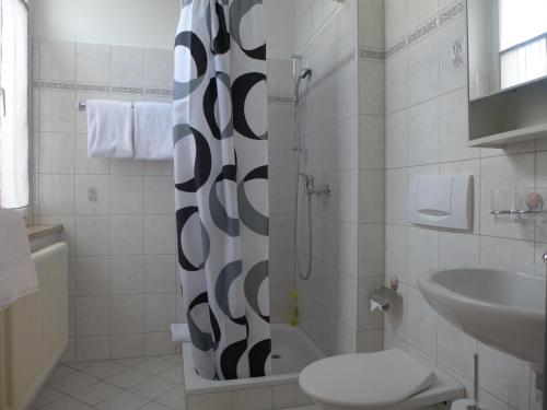 Glovelier格尔餐厅及酒店的带淋浴、卫生间和盥洗盆的浴室