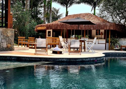 布希奥斯Taman Búzios Hotel的一个带桌椅和游泳池的度假酒店