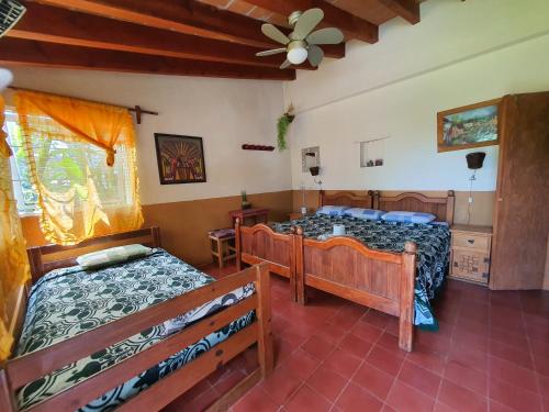 迪坡斯特兰Posada El paraíso的一间卧室配有两张床和吊扇