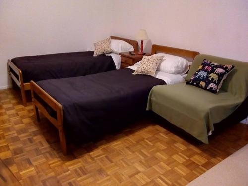 布宜诺斯艾利斯Cortina的客房内的两张床和一把椅子