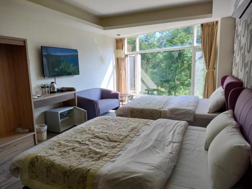 南庄乡百合山庄的酒店客房设有两张床和窗户。