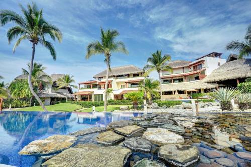 锡瓦塔塔内霍Las Palmas Luxury Villas的一个带游泳池和棕榈树的度假村