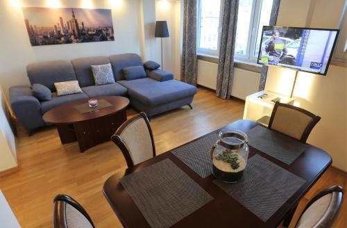 华沙Apartament MGM Karmelicka的客厅配有桌子和沙发