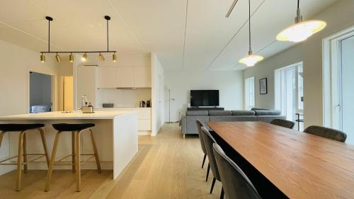 哥本哈根ApartmentInCopenhagen Apartment 1463的厨房以及带桌椅的起居室。