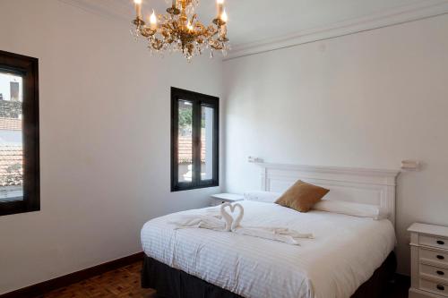 巴尔韦尔德ELHIERRO BED&URBAN I的卧室配有白色的床和吊灯。
