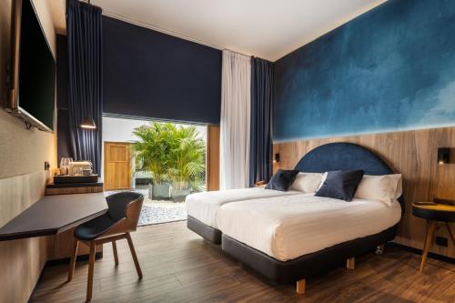 大加那利岛拉斯帕尔马斯Boutique Hotel Cordial La Peregrina的一间卧室配有一张床、一张书桌和一个窗户。