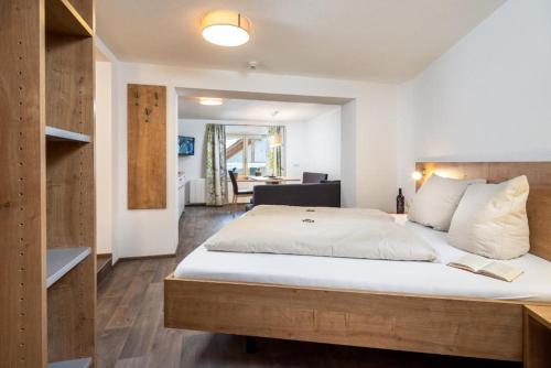 湖城Haus Sabrina Masnerjoch的卧室配有一张带白色床单和枕头的大床。