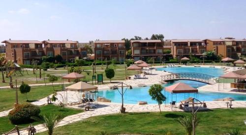 艾因苏赫纳Marina Wadi Degla A Ground Chalet Near to the Beach in Ain Sokhna的一座带大型游泳池和部分建筑的度假村