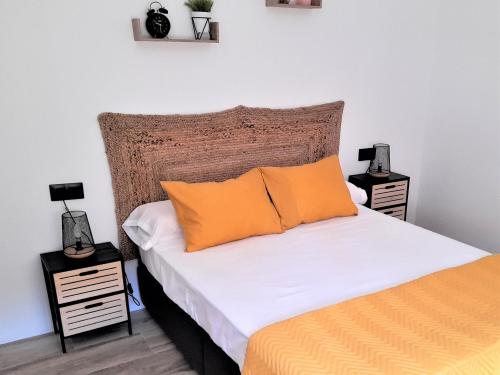 瓦拉雷伊La CaSita的一间卧室配有带橙色枕头和2个床头柜的床