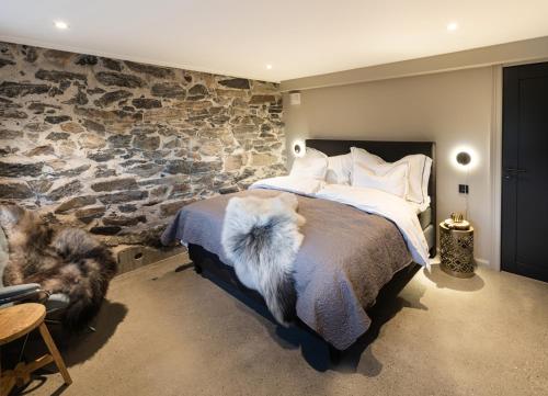 GodøyGodo Lodge的一间卧室设有石墙和一张床